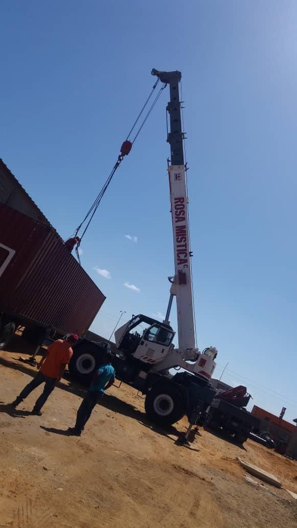 Grúa realizando maniobra de izaje de contenedor - Rosa Mística Construcciones